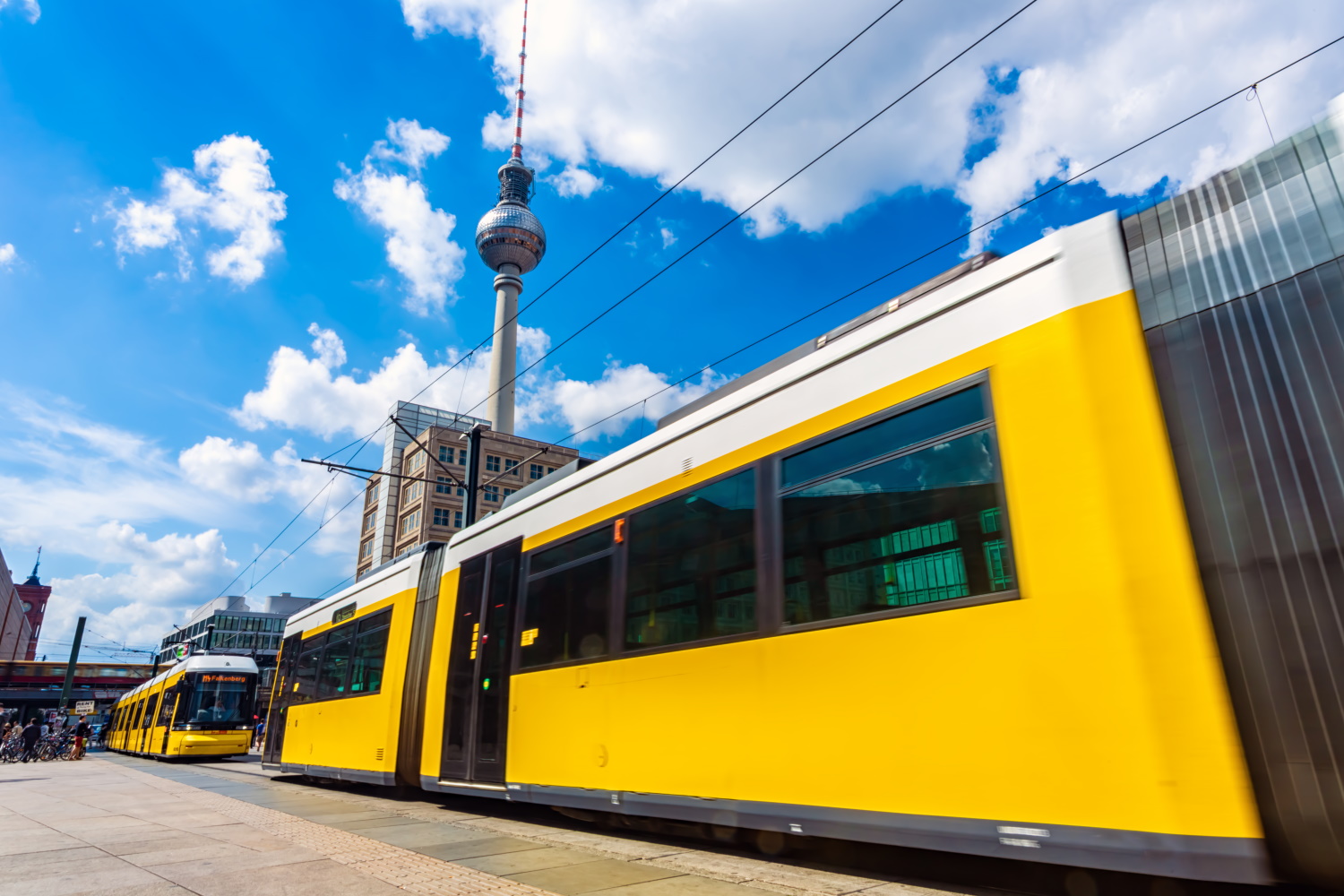 Eine Straßenbahn des öffentlichen Nahverkehrs steht am Gleis an einem Bahnhof.